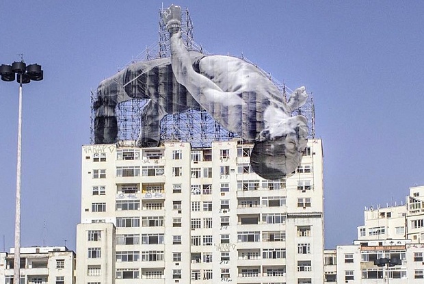 One of French artist JR's larger-than-life athletes looms--er, leaps--over the Rio skyline. Image c/o JR-net.art and The Art Newspaper.